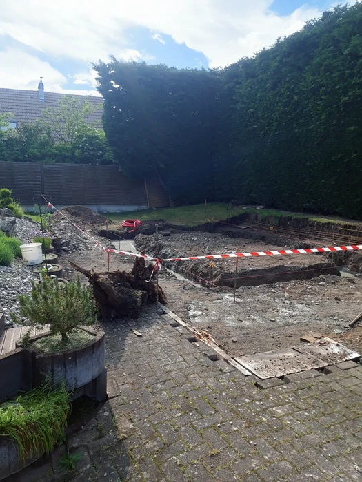 Chantier de construction extérieur dans jardin résidentiel avec excavation en cours