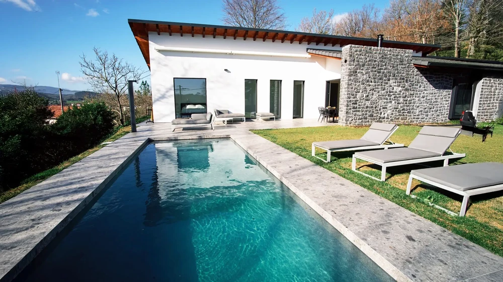 Villa contemporaine avec piscine rectangulaire à débordement, eau turquoise cristalline