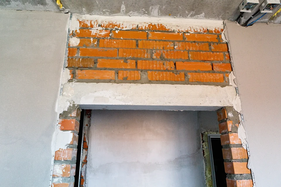 Architecte professionnel dans la protection des murs de mesure du chapeau dur avec bande de montage près de l'échelle de marche sécurité et équipement pendant le processus de rénovation