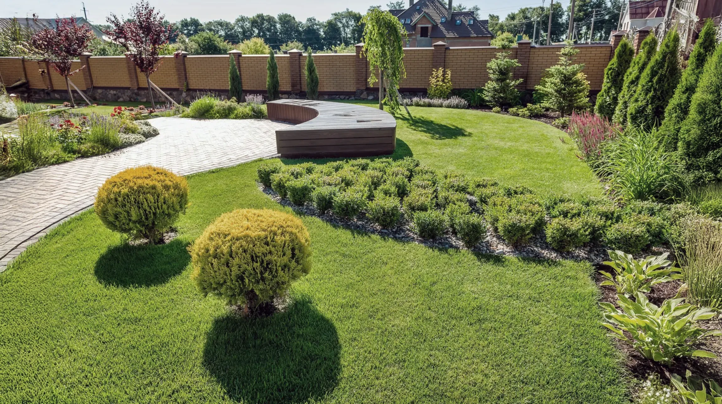 Terrasse extérieure aménagée avec salon de jardin en rotin naturel comprenant deux fauteuils et table basse ronde