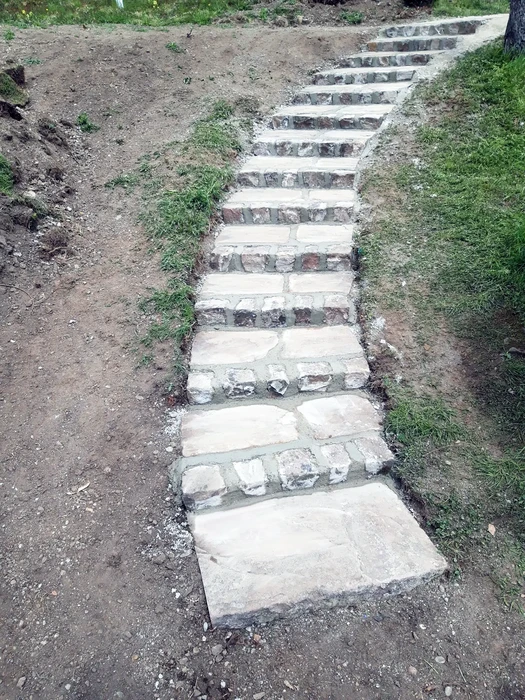 Jardin résidentiel en cours d'aménagement paysager avec zones de graviers décoratifs, copeaux de bois et plantations arbustives