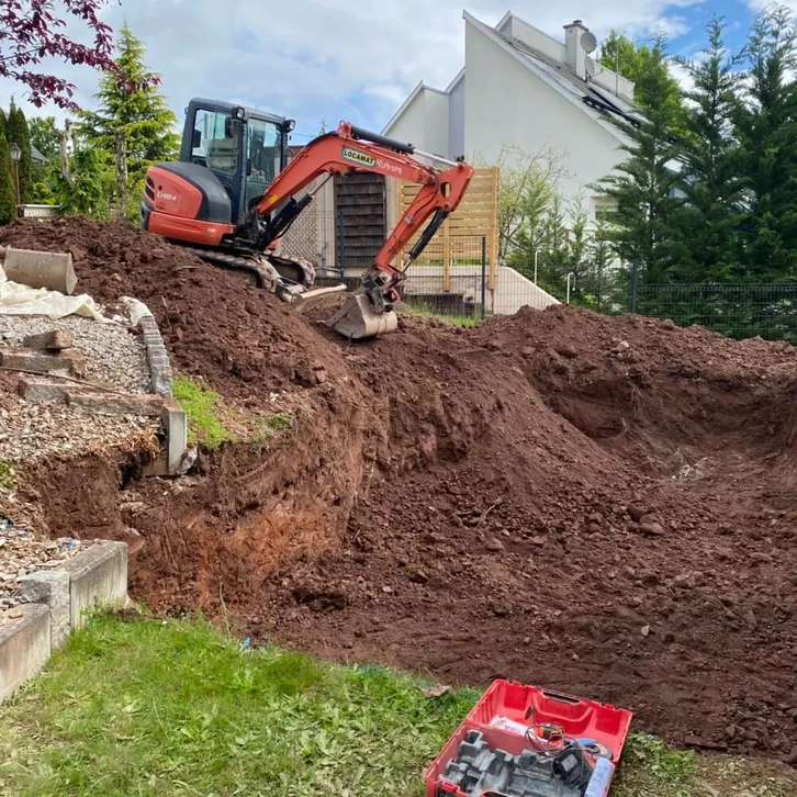La machinerie lourde de l'excavatrice Bulldozer travaille ensemble pour déblayer le terrain d'excavation sur le chantier de construction, la poussière monte alors qu'ils creusent dans le sol, se préparant pour le développement à venir